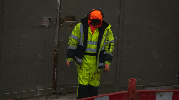 Worker in a fluorescent jacket with silver retroreflective tape bands